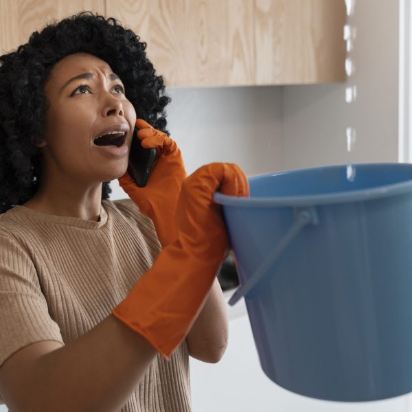 femme qui panique devant fuite d'eau